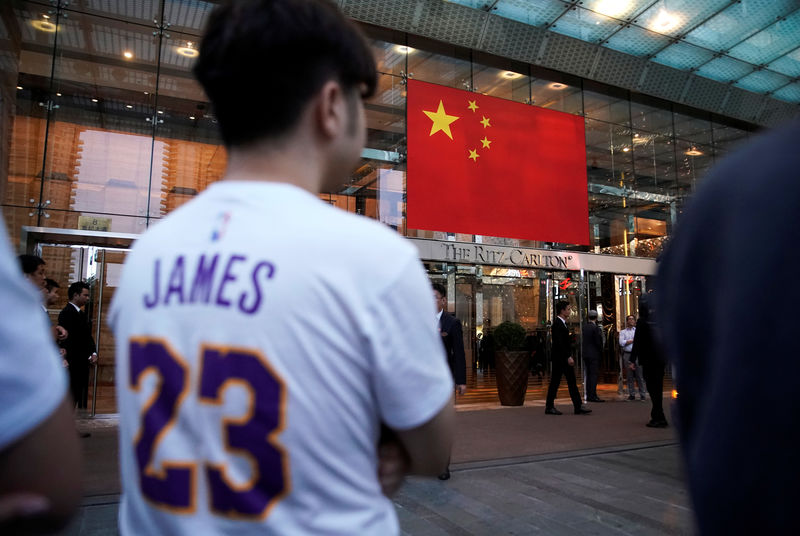 © Reuters. Man wearing a T-shirt with name and number of LeBron James of NBA Los Angeles Lakers stands outside a Ritz-Carlton hotel in Shanghai,