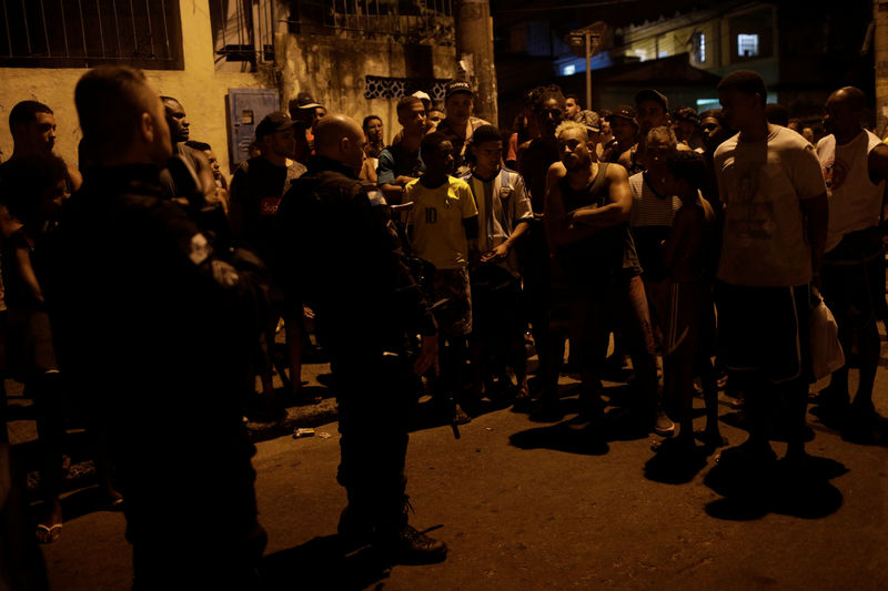 © Reuters. Residents argue with policemen next to the body of the jiu-jitsu teacher Jean Rodrigo da Silva, who was shot dead during a police operation in Alemao slums complex after he left his social project where he gave jiu-jitsu classes to kids in Rio de Janeiro