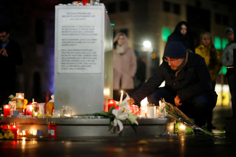 © Reuters. A person puts a candle at central market square in Halle