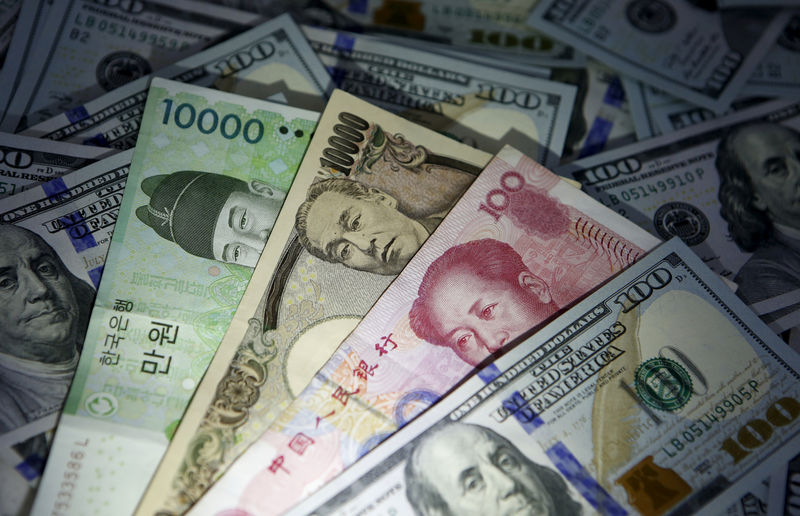 © Reuters. South Korean won, Chinese yuan and Japanese yen notes are seen on U.S. 100 dollar notes in this picture illustration taken in Seoul