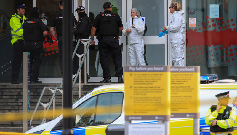 © Reuters. Police forensic officers stand with armed officers outside the Arndale shopping centre after several people were stabbed in Manchester, Britain