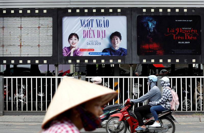 © Reuters. Bikers go past an empty space where a promotional poster for the DreamWorks film "Abominable" stood before being taken down at a cinema in Hanoi