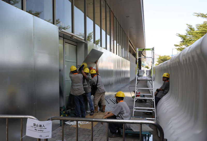 © Reuters. Workers reinforce doors to the Legislative Council Complex, in central Hong Kong