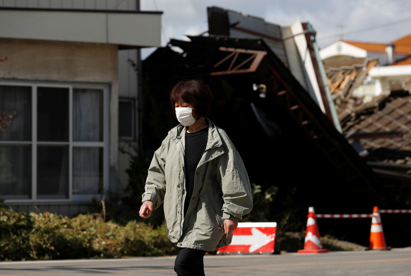 © Reuters. A woman walks near flooded houses, in the aftermath of Typhoon Hagibis, in Koriyama