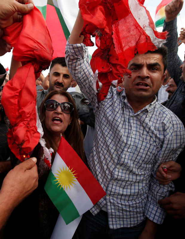 © Reuters. Iraqi Kurds burn the Turkish flag during a demonstration outside the United Nations building, against Turkey's incursion in Syria, in Erbil