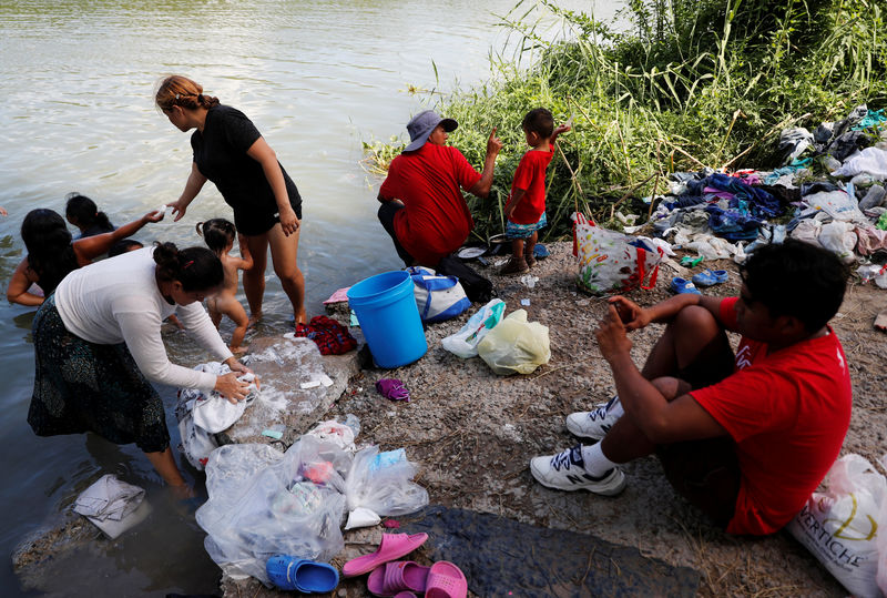 © Reuters. Central American migrants wash their clothes in the Rio Bravo near an encampment in Matamoros