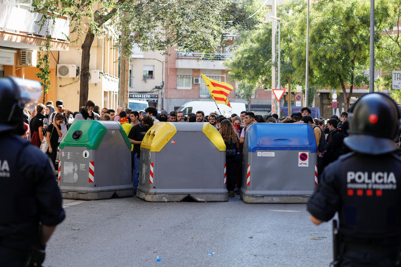 © Reuters. Un manifestante muestra videos de enfrentamientos con la policía en un teléfono móvil a un policía mientras los manifestantes se reúnen mientras el líder del partido de Ciudadanos, Albert Rivera, visita el centro Saudade en Barcelona, España, el 16
