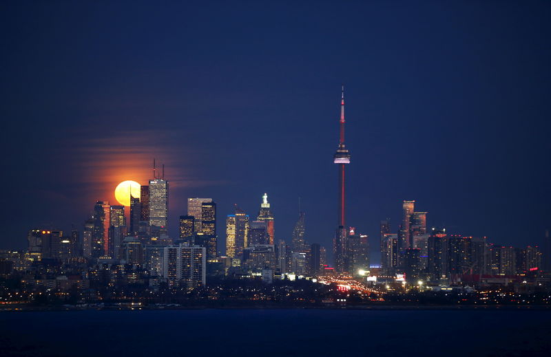 © Reuters. The moon rises behind the skyline and financial district in Toronto