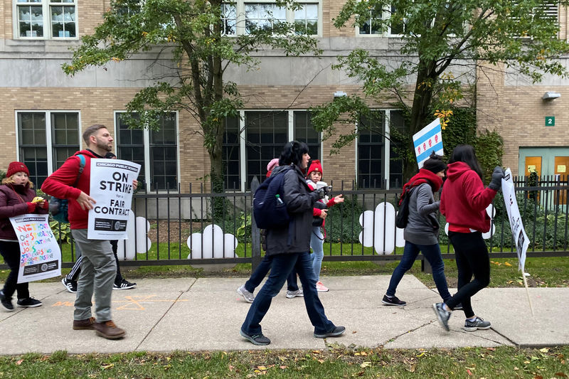 © Reuters. Teachers and parents picket in front of and near Helen C. Pierce School of International Studies during the first day of a teacher strike in Chicago