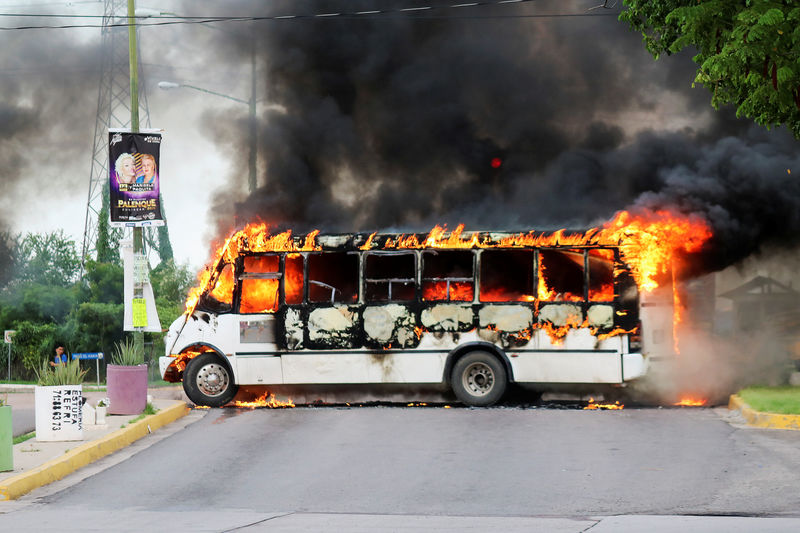 © Reuters. A burning bus, set alight by cartel gunmen to block a road, is pictured during clashes with federal forces following the detention of Ovidio Guzman, son of drug kingpin Joaquin "El Chapo" Guzman, in Culiacan
