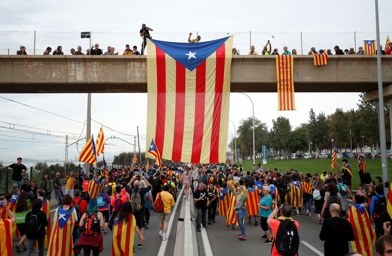 © Reuters. Una estelada (banderas separatista catalana) cuelga de un paso elevado mientras los manifestantes marchan durante la huelga general de Cataluña en El Masnou, España