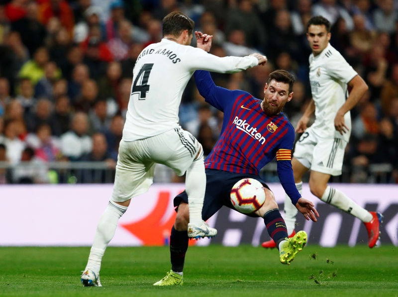 © Reuters. Imagen de archivo del delantero del Barcelona Lionel Messi disputando un balón con el defensa del Real Madrid Sergio Ramos durante un partido de la Liga en el estadio Santiago Bernabéu, Madrid, España.