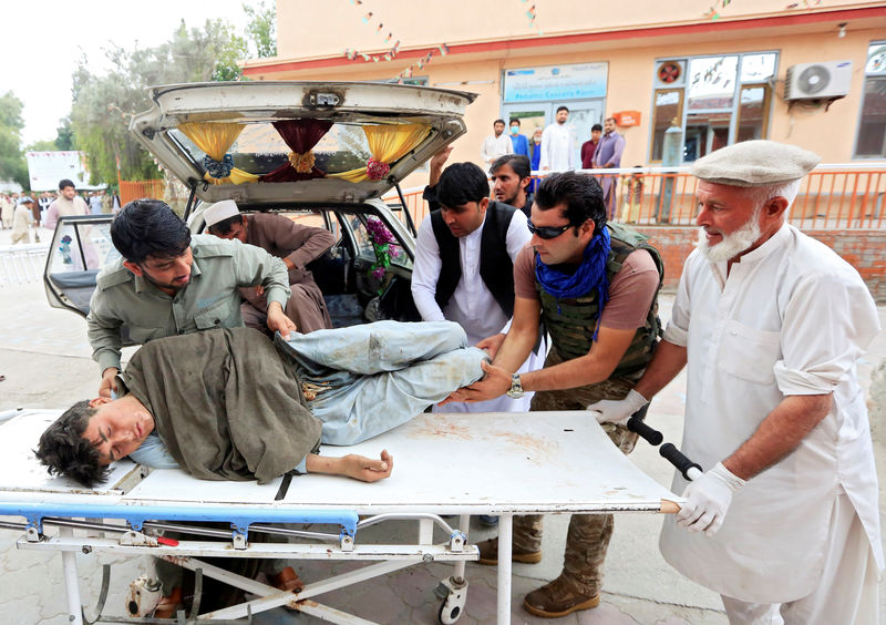 © Reuters. Men carry an injured person to a hospital after a bomb blast at a mosque, in Jalalabad, Afghanistan