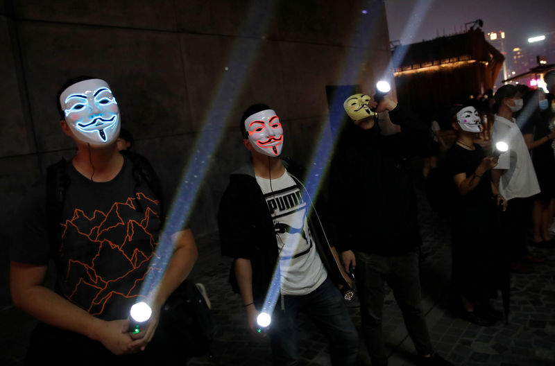 © Reuters. People wearing Anonymous masks use flashlights during an anti-government protest in Hong Kong