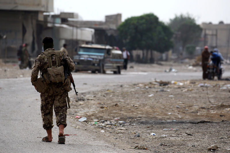 © Reuters. Turkey-backed Syrian rebel fighter walks near Ras al Ain Town