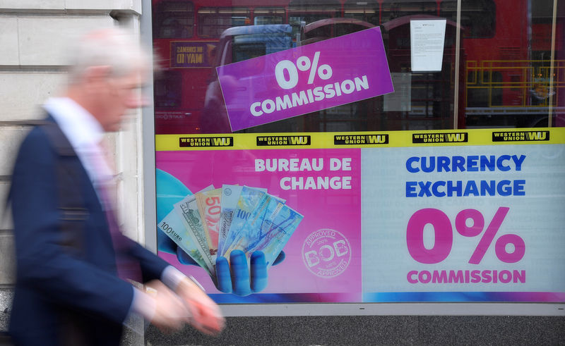 © Reuters. FILE PHOTO: A man walks past a currency exchange outlet in London