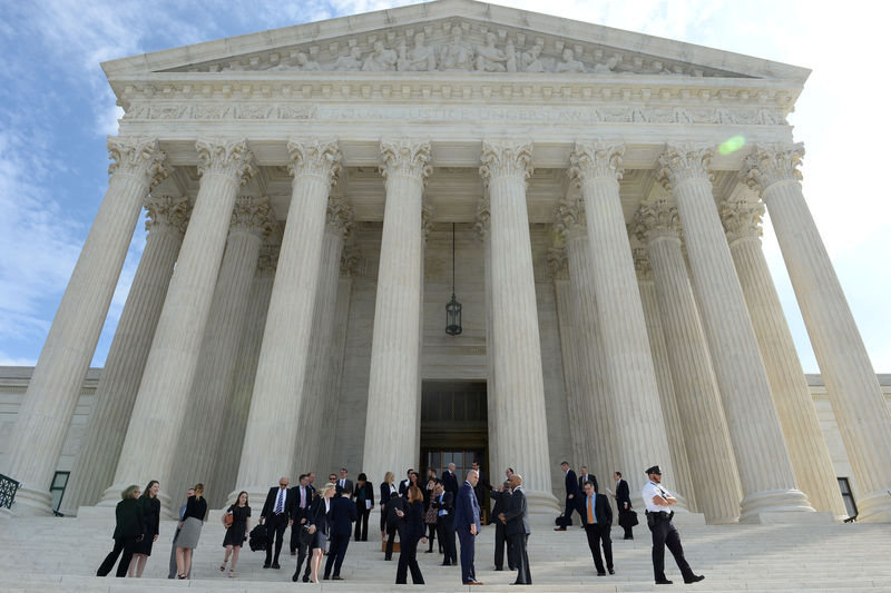 © Reuters. FILE PHOTO: People leave the Supreme Court after it resumed hearing oral arguments at the start of its new term in Washington