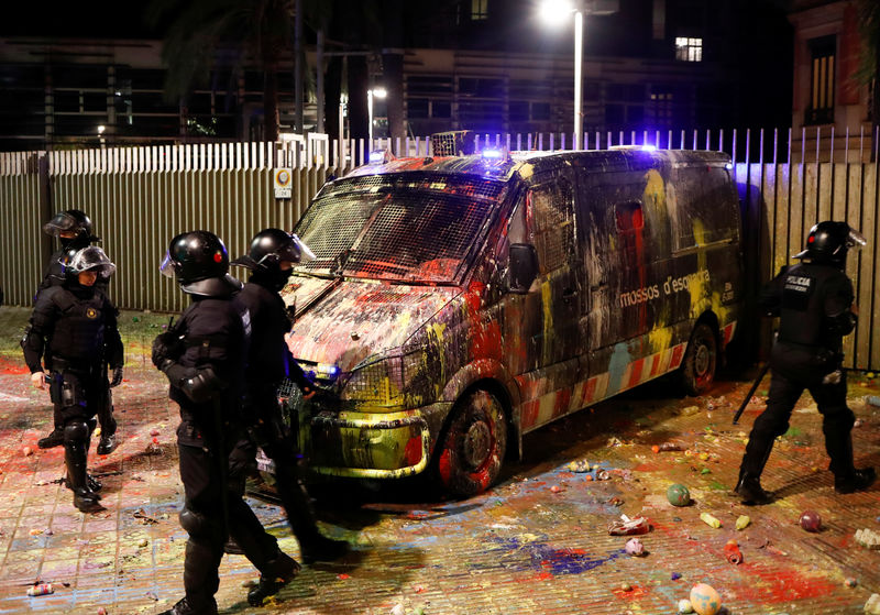 © Reuters. Police officers check a van that was covered with paint during a protest outside the Spanish government delegation offices in Barcelona