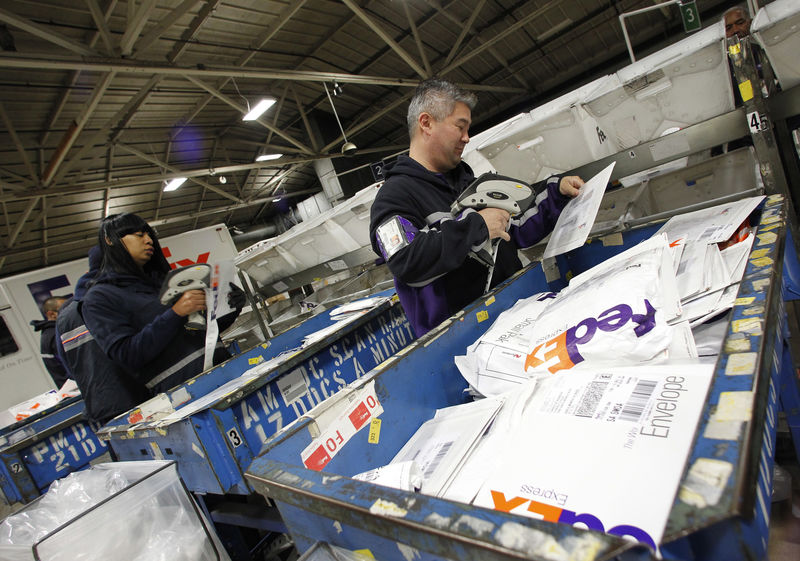 © Reuters. Handlers place letters and envelopes into cartons at the Marina Del Rey, California FedEx station