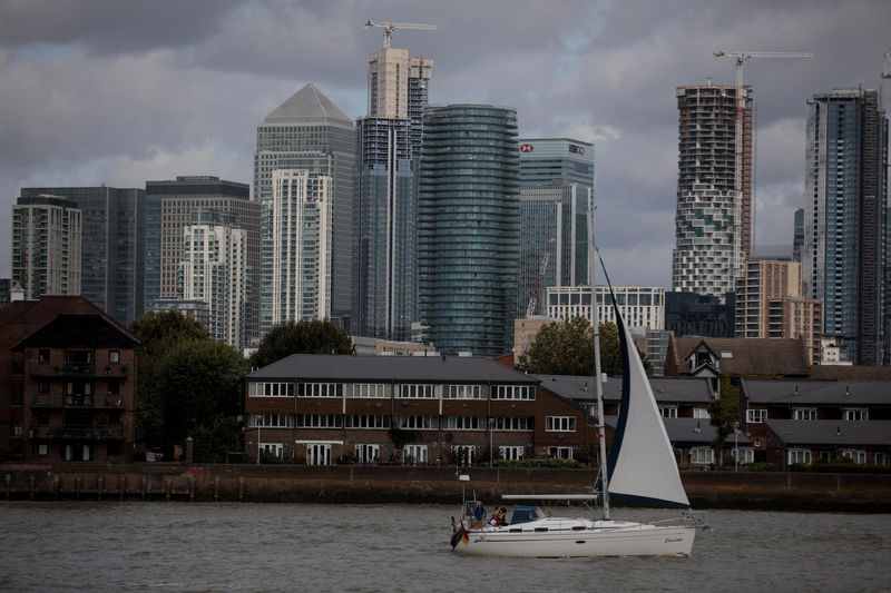 © Reuters. FOTO DE ARCHIVO: Un velero pasa por el distrito financiero de Canary Wharf en el río Támesis en Londres