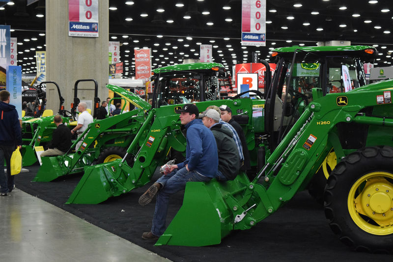 © Reuters. FILE PHOTO: People look at Deere equipment as they attend National Farm Machinery show in Louisville