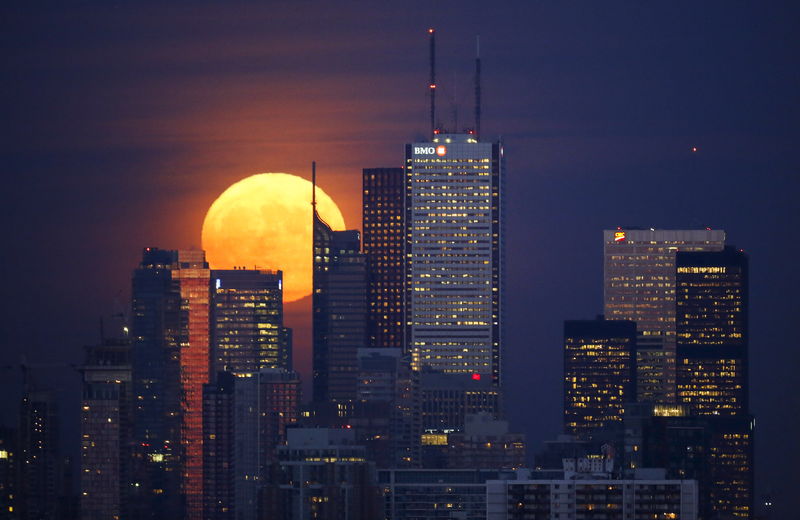 © Reuters. The moon rises behind the skyline and financial district in Toronto