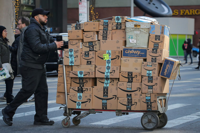 © Reuters. FILE PHOTO: A delivery person pushes a cart full of Amazon boxes in New York