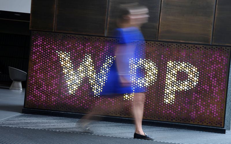 © Reuters. A woman walks past signage for WPP Group, the largest global advertising and public relations agency at their offices in London