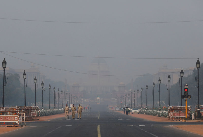 © Reuters. Police officers walk near India's Presidential Palace on a smoggy morning in New Delhi