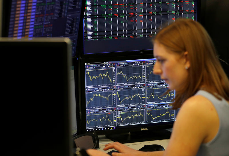 © Reuters. A financial trader works at their desk at CMC Markets in the City of London
