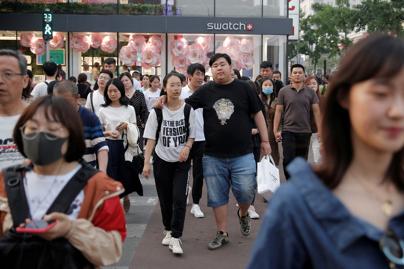© Reuters. FILE PHOTO: People walk in Wangfujing shopping street in Beijing