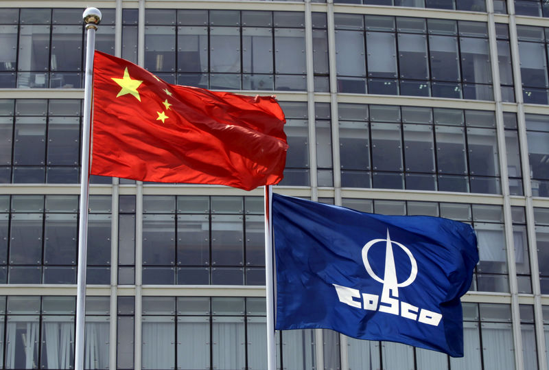 © Reuters. FILE PHOTO: A COSCO company flag and a Chinese national flag flying in front of the company's headquarters in Beijing