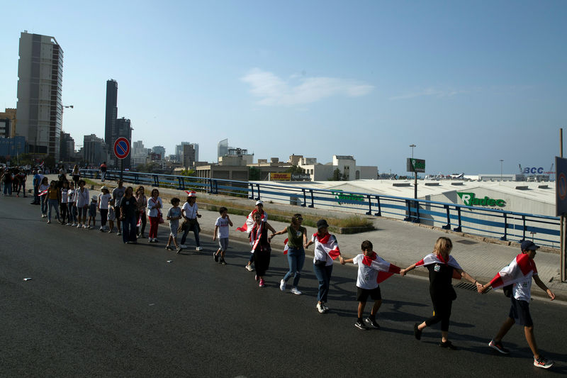 © Reuters. المحتجون في لبنان يشكلون سلسلة بشرية بطول 171 كيلومترا