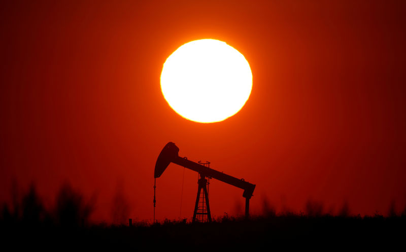 © Reuters. FILE PHOTO: The sun sets behind a pump-jack outside Saint-Fiacre