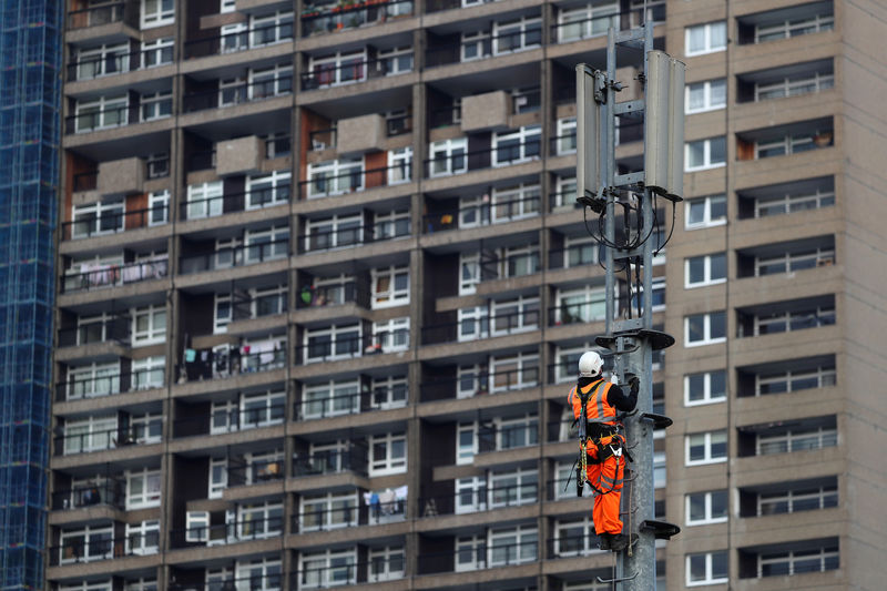 © Reuters. FILE PHOTO: An engineer works on a mobile telephony mast in London