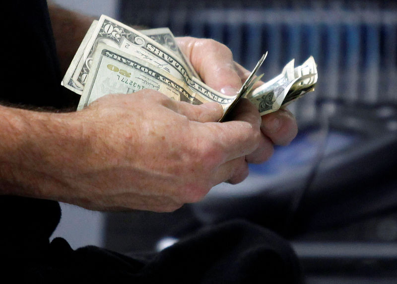 © Reuters. FILE PHOTO: A customer counts his cash at the register while purchasing an item at a Best Buy store in Flushing