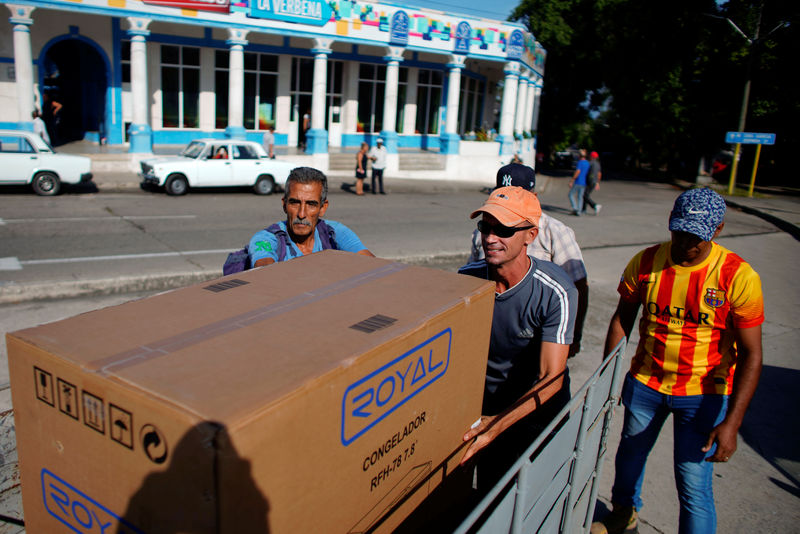 © Reuters. Taxi driver Orlando Cervantes loads his trailer car with a freezer bought from a shop selling products for dollars in Havana