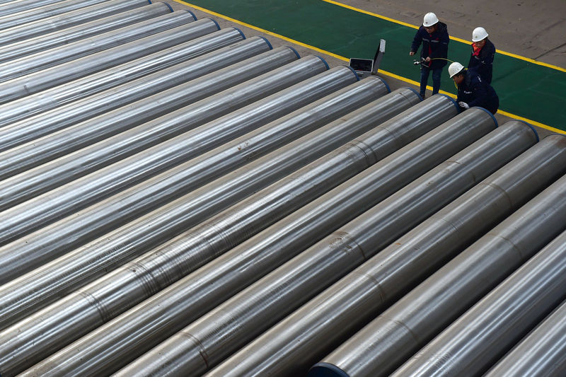 © Reuters. Workers check on seamless steel pipes at a factory of a steel products manufacturer in Cangzhou, Hebei