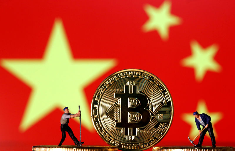 © Reuters. FILE PHOTO: Picture illustration of small toy figurines and representations of the Bitcoin virtual currency displayed in front of an image of China's flag