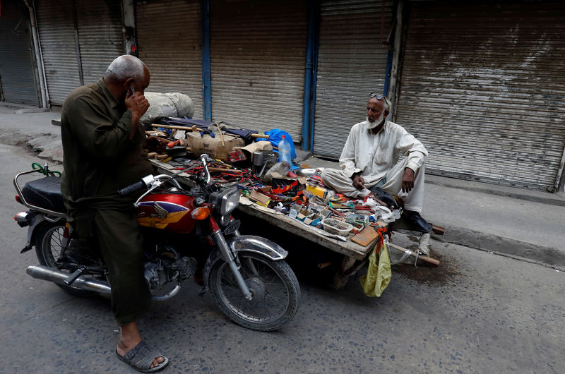 © Reuters. A man sells hardware tools from his cart in front of closed shops during a country-wide lock down by the traders and business community, against what they say is imposition of taxes by the government in Rawalpindi