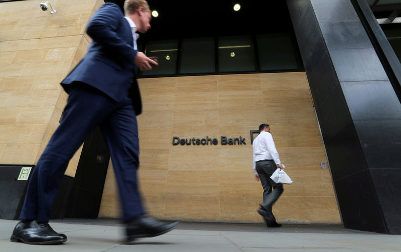 © Reuters. FILE PHOTO: People walk past a Deutsche Bank office in London