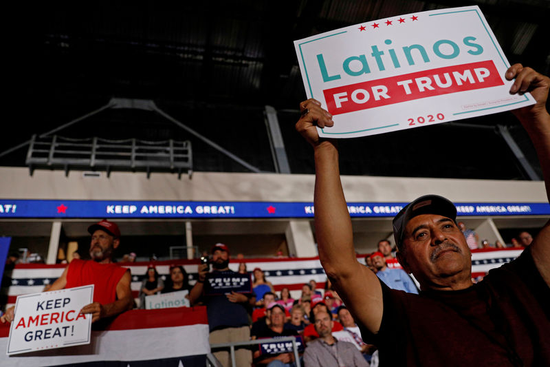 © Reuters. FILE PHOTO: Members of the audience look on as U.S. President Donald Trump delivers remarks at a Keep America Great rally