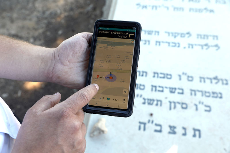 © Reuters. A man demonstrates how to use "Gravez", which offers turn-by-turn voice directions to help cemetery visitors navigate large graveyards in search of a loved-one's resting place, during an interview with Reuters at Givat Shaul cemetery in Jer