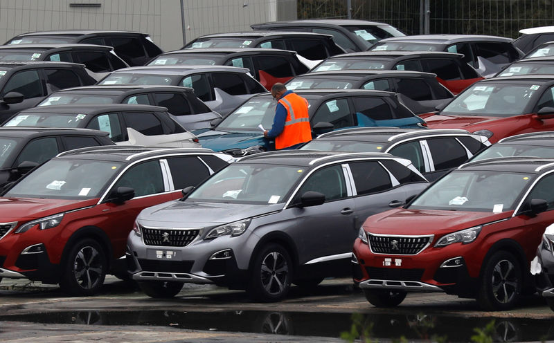 © Reuters. A worker checks cars at the PSA Peugeot Citroen plant in Poissy, near Paris