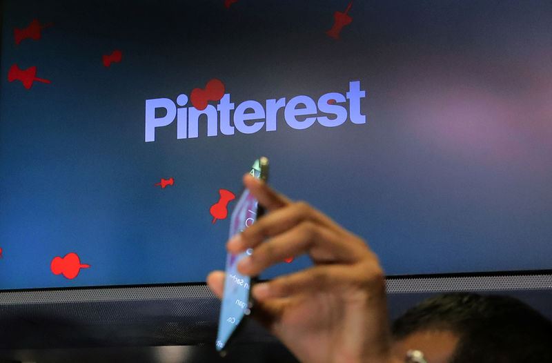 © Reuters. A guest hold up a phone during the Pinterest Inc. IPO on the floor of the NYSE in New York