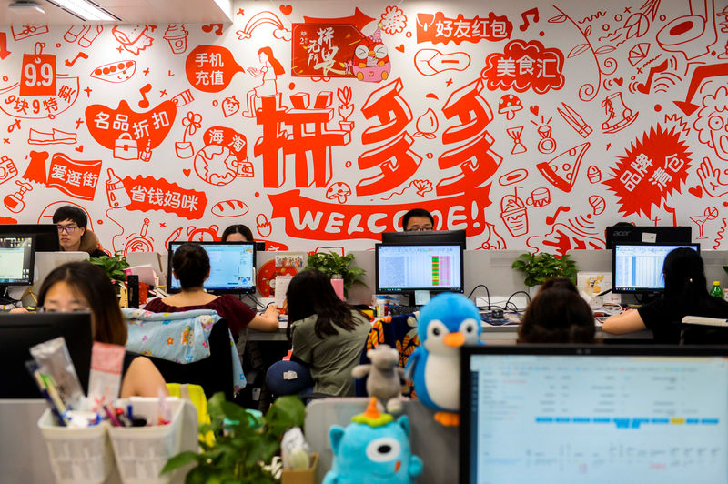 © Reuters. People are seen at their desks at the headquarters of Chinese online group discounter Pinduoduo in Shanghai