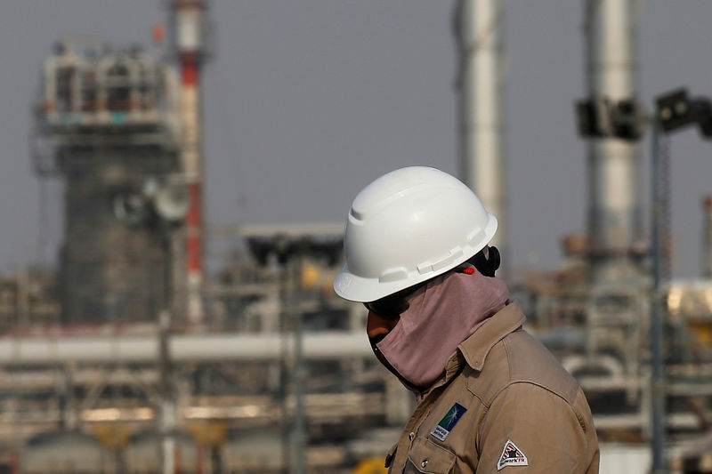 © Reuters. FILE PHOTO: An employee looks on at Saudi Aramco oil facility in Abqaiq