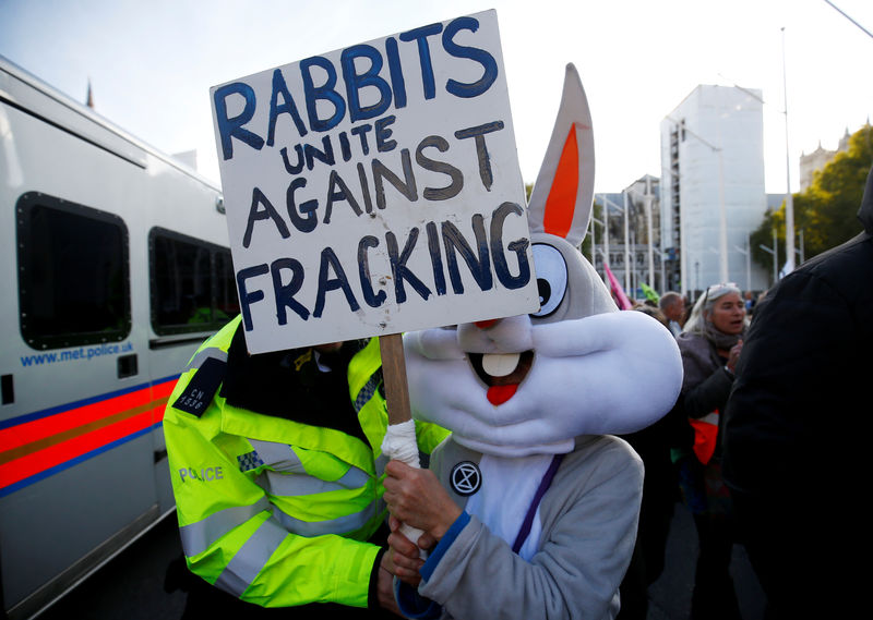 © Reuters. FILE PHOTO: A police officer moves a protester outside the Houses of Parliament during a demonstration against fracking, in London