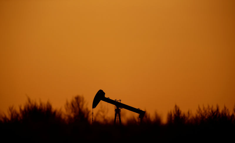 © Reuters. The sun sets behind a pump-jack outside Saint-Fiacre