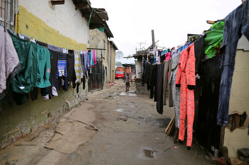 © Reuters. FILE PHOTO: A child walks past washing in Alexandra township in Johannesburg
